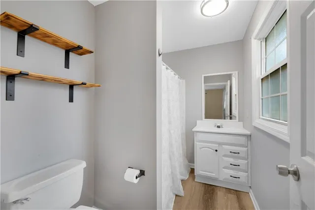 a bathroom with a toilet a sink a bath tub and mirror