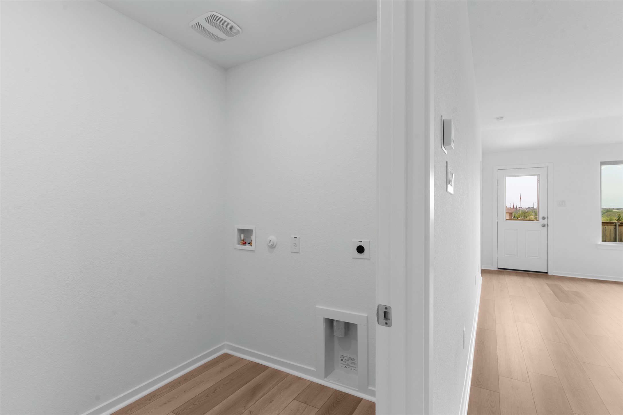 13701 Tucker Hedge Pass Elgin, TX 78621 - Photo 10 of 21 Dedicated utility space featuring wood-finish flooring, washer hookups, dryer vent, and a ceiling vent
