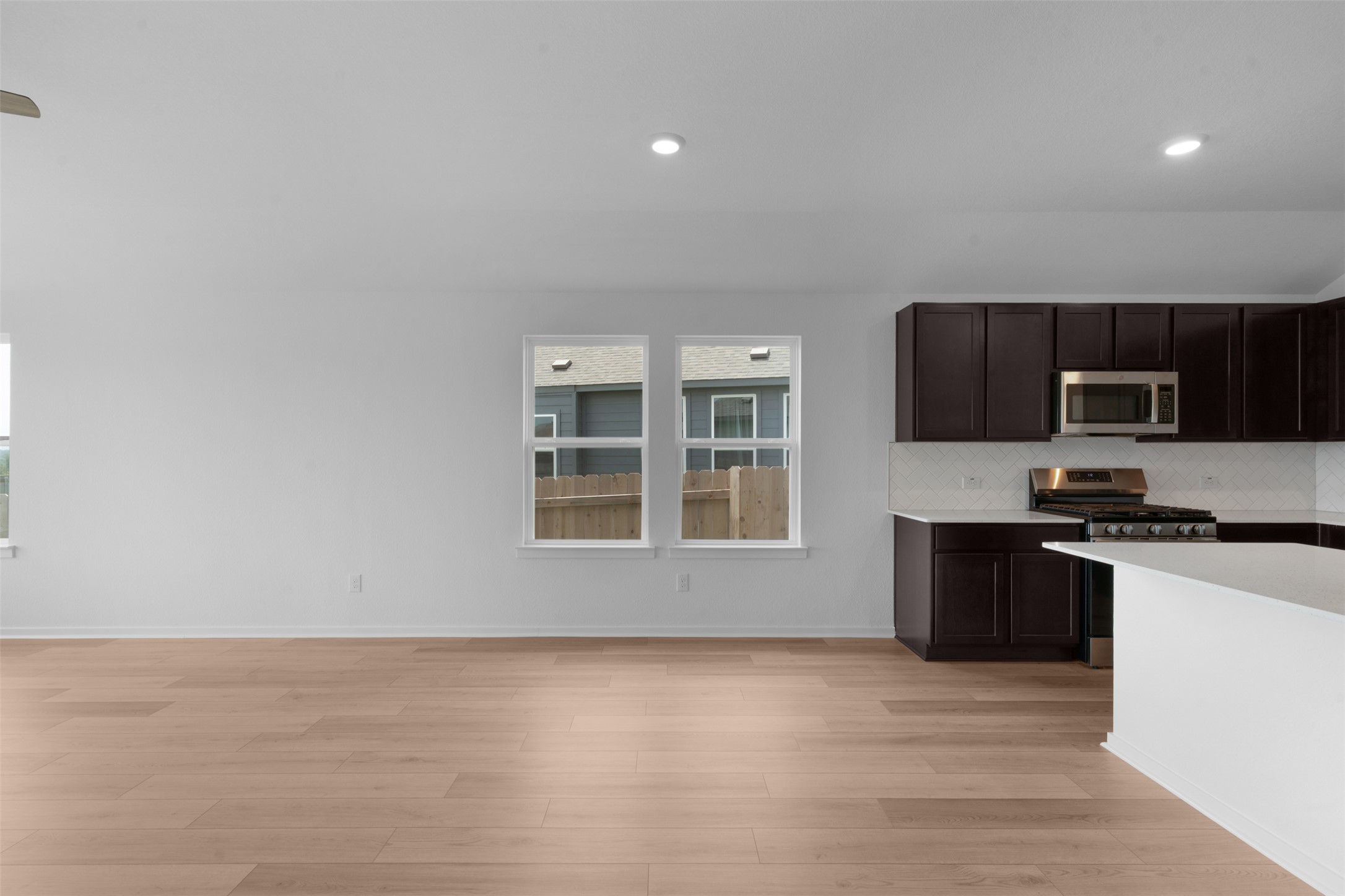 13701 Tucker Hedge Pass Elgin, TX 78621 - Photo 11 of 21 Open-concept living area featuring light wood-finish flooring, recessed lighting, and a contemporary kitchen