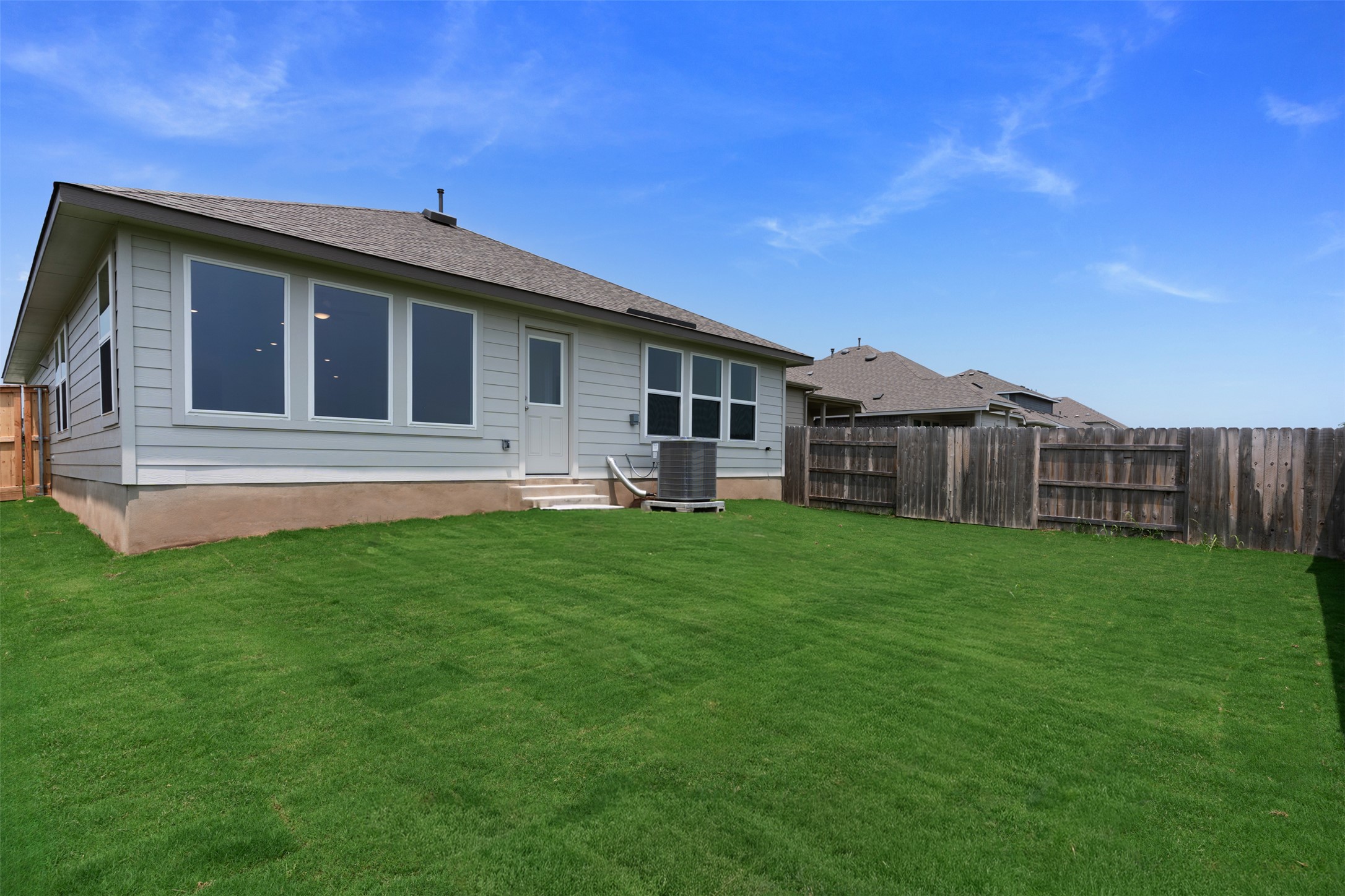 13701 Tucker Hedge Pass Elgin, TX 78621 - Photo 16 of 21 Expansive green lawn with a wooden privacy fence