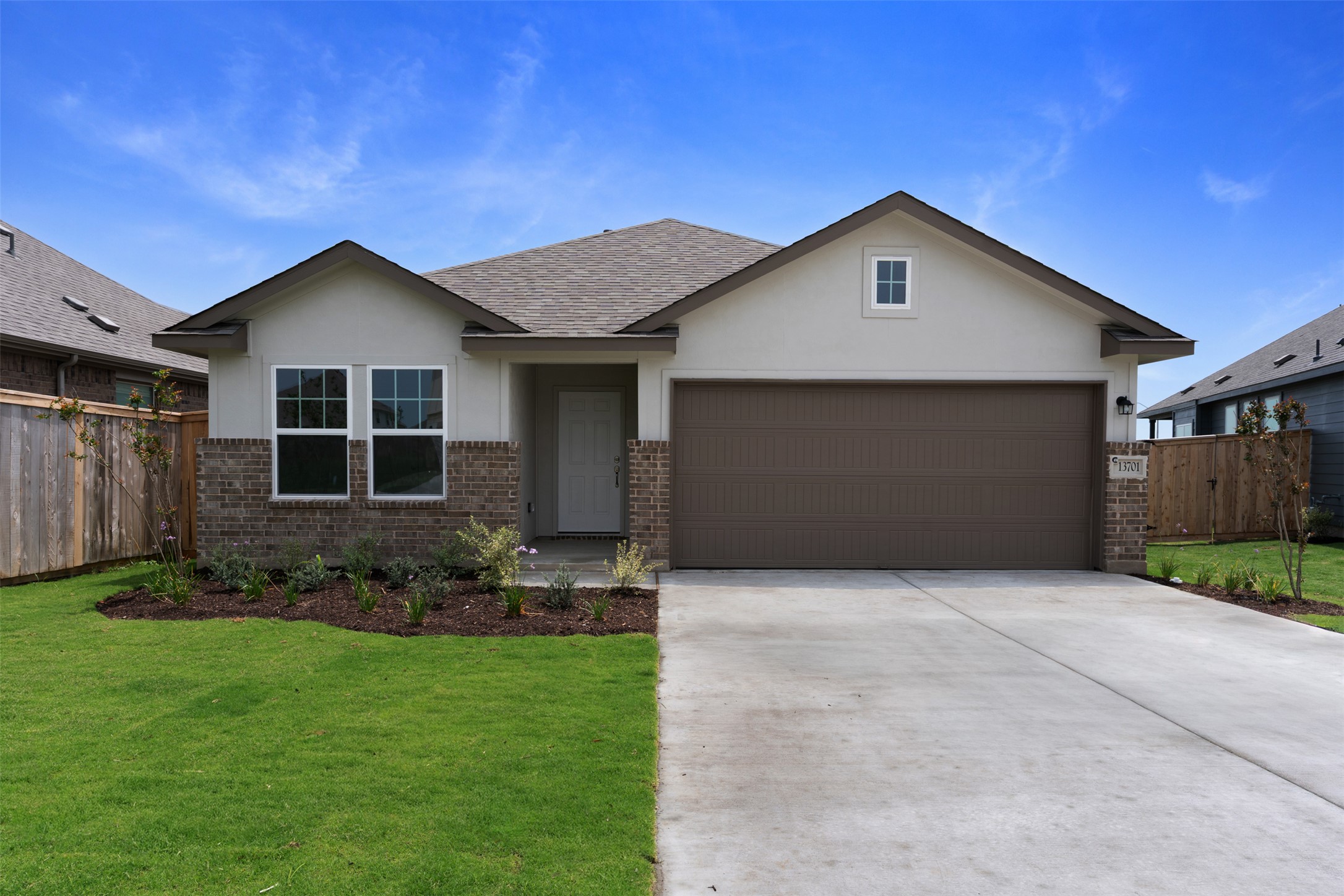 13701 Tucker Hedge Pass Elgin, TX 78621 - Photo 1 of 21 Modern single-story residence featuring a two-car garage, brick and stucco exterior, and a gabled roofline
