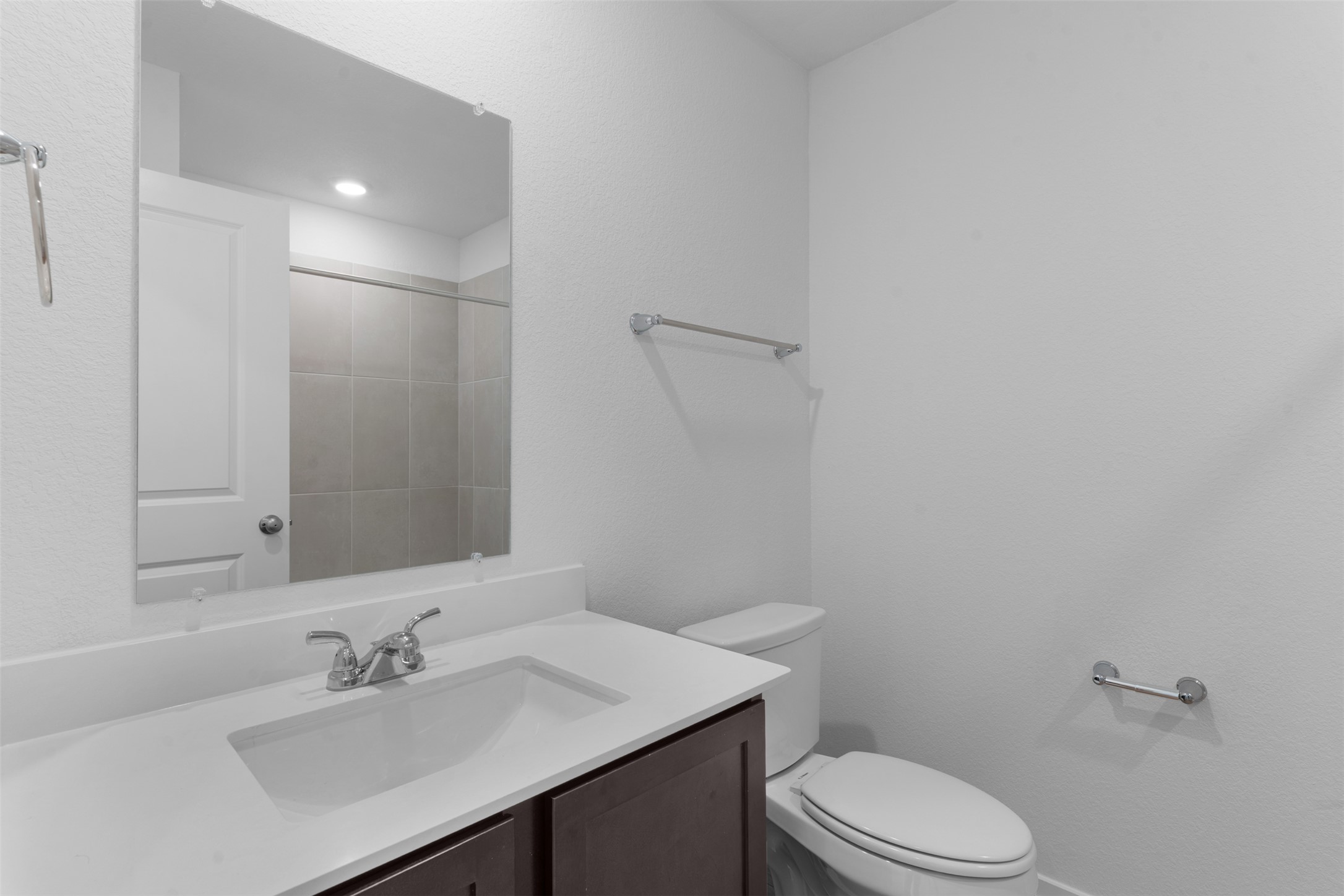 13701 Tucker Hedge Pass Elgin, TX 78621 - Photo 2 of 21 Bathroom featuring a single vanity with dark wood-finish cabinetry, white countertop, and an integrated rectangular sink