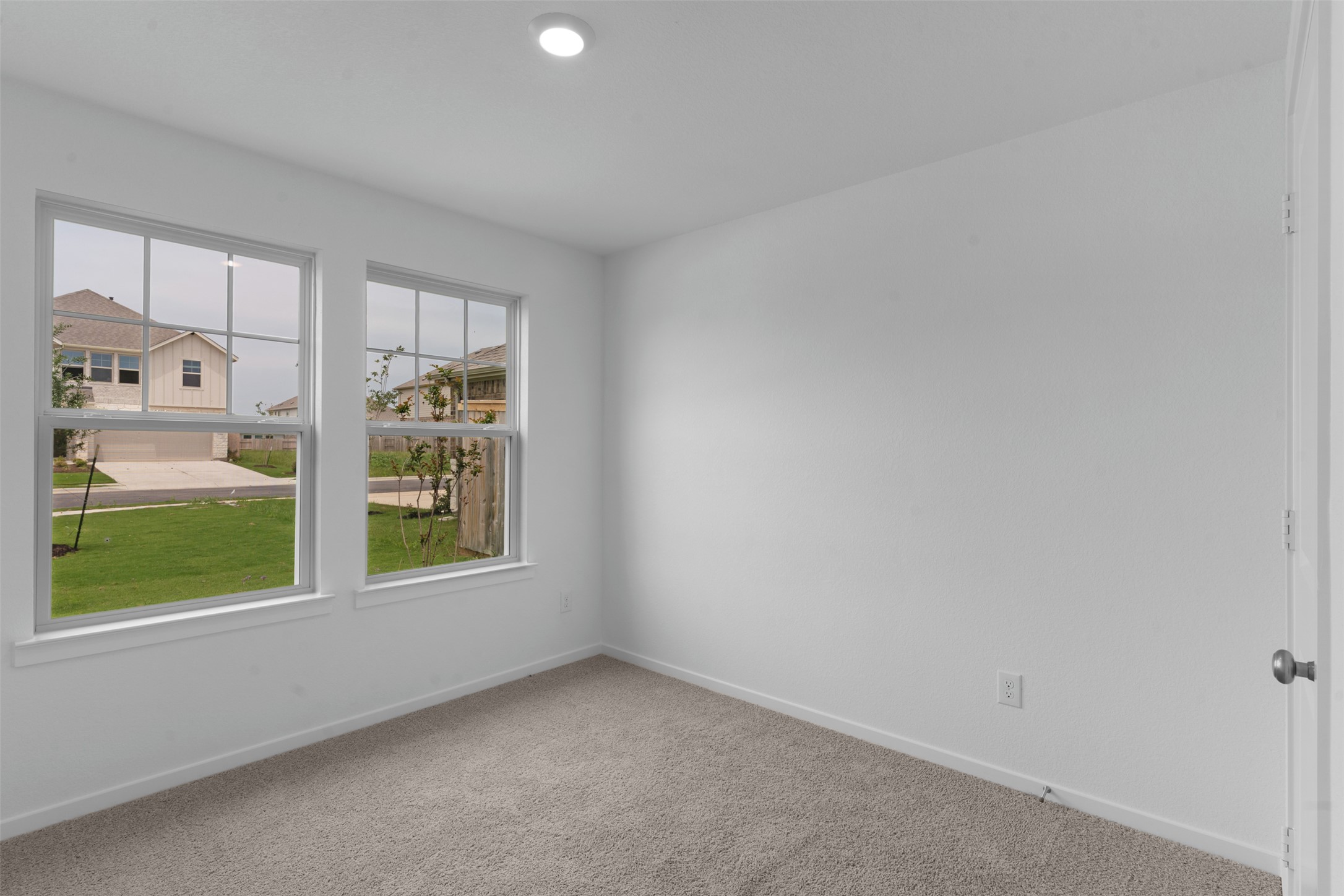 13701 Tucker Hedge Pass Elgin, TX 78621 - Photo 3 of 21 Bright room with dual pane windows, neutral carpeting, and a recessed ceiling light