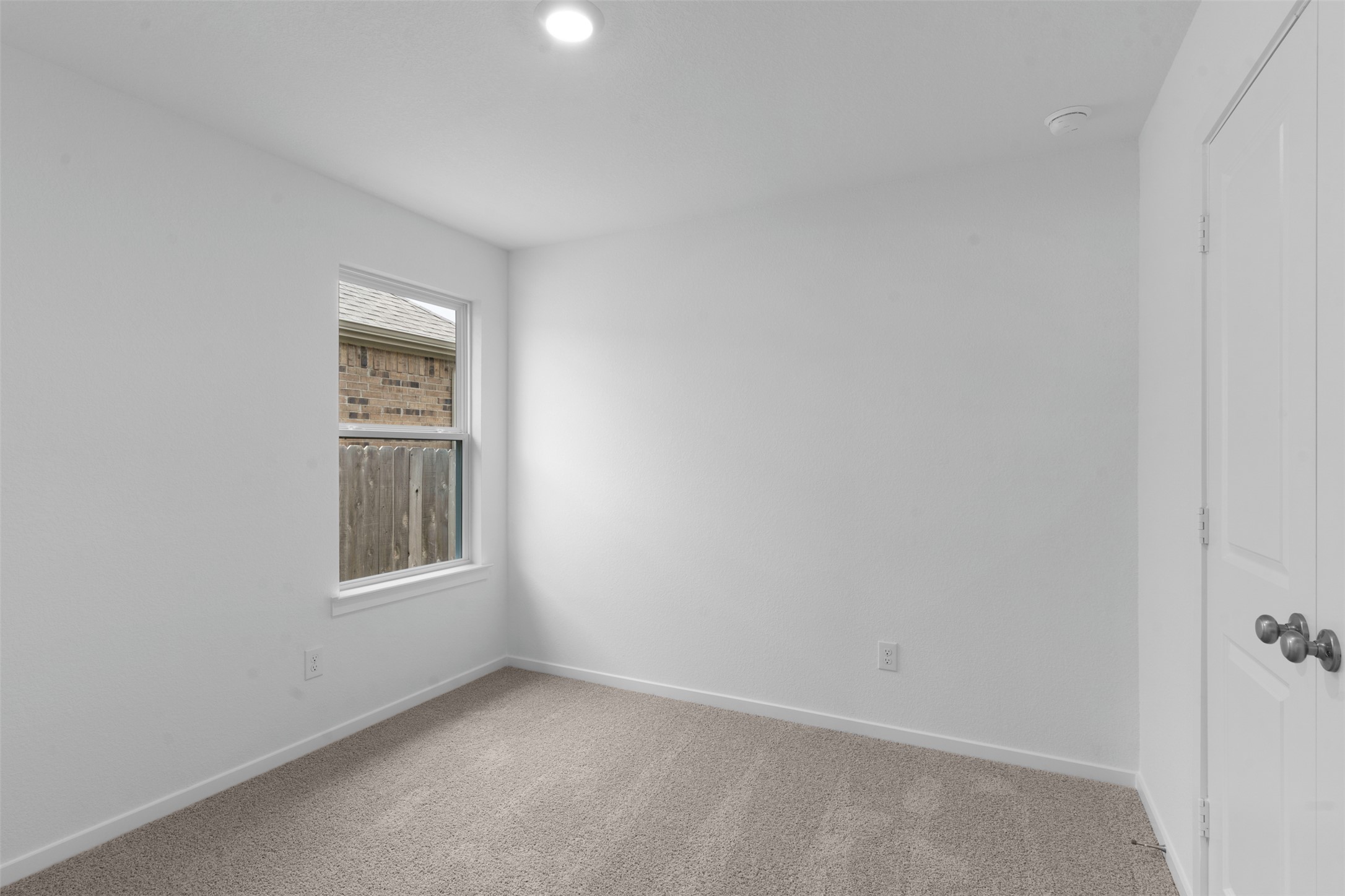13701 Tucker Hedge Pass Elgin, TX 78621 - Photo 9 of 21 Neutral tone wall finishes, gray carpeting, recessed ceiling lighting, a single window, and a white interior door with dark hardware