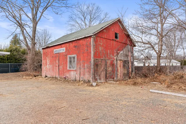a backyard of a house with large trees and a covered with snow