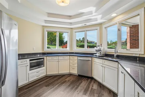 a kitchen with granite countertop stainless steel appliances a stove sink and cabinets