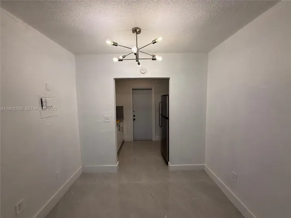 an empty room with a ceiling fan and a bathroom