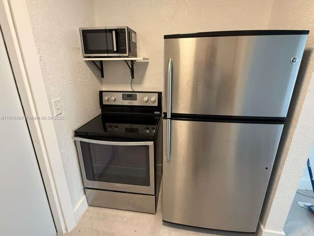 1251 Northwest 61st Street, Unit 5 Miami, FL 33142 - Photo 15 of 15 a view of a refrigerator in kitchen and wooden floor