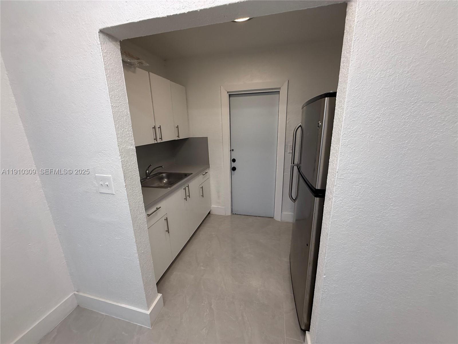 1251 Northwest 61st Street, Unit 5 Miami, FL 33142 - Photo 4 of 15 a view of hallway with washer and dryer
