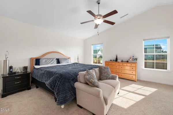 a spacious bedroom with a bed a window and a chandelier