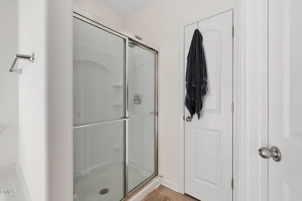 a bathroom with a shower and a glass door