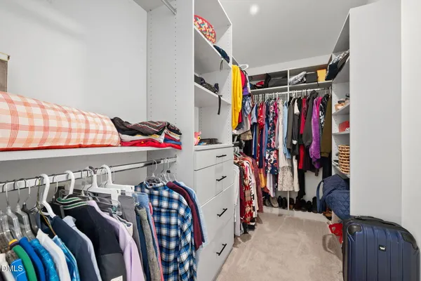 a view of walk in closet with clothes and shoes
