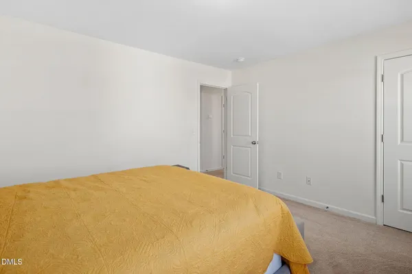 a bed sitting in a spacious bedroom next to a bathroom