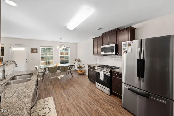 a kitchen with stainless steel appliances granite countertop a refrigerator stove microwave and sink