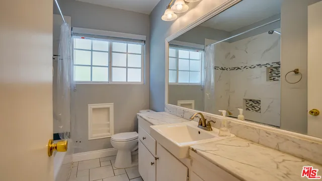 a view of an empty room with a fireplace and a window