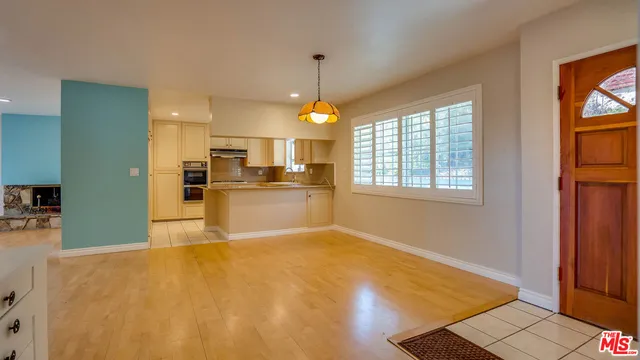 a room with white cabinets and wooden floor