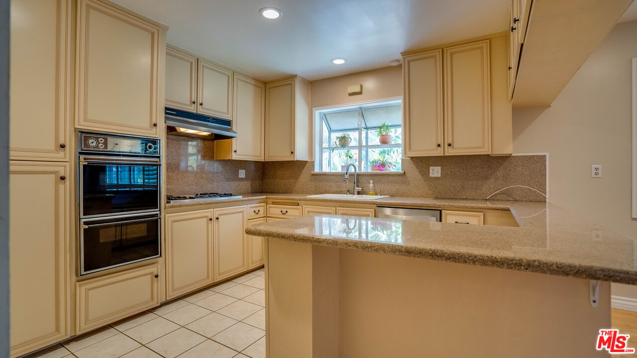 9631 Crystal View Drive Tujunga, CA 91042 - Photo 36 of 57 a kitchen with granite countertop a refrigerator sink and cabinets