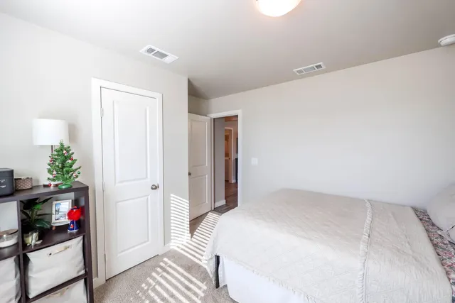 a bedroom with a bed and a potted plant
