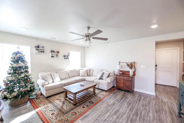a living room with furniture and a large window with wooden floor