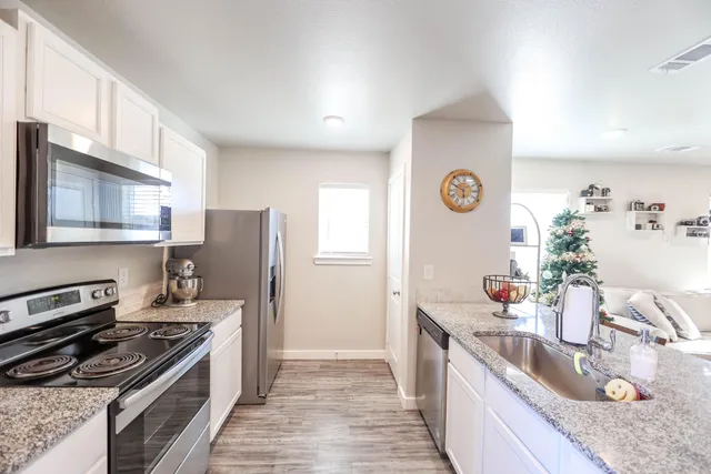a kitchen with stainless steel appliances granite countertop a sink stove and refrigerator