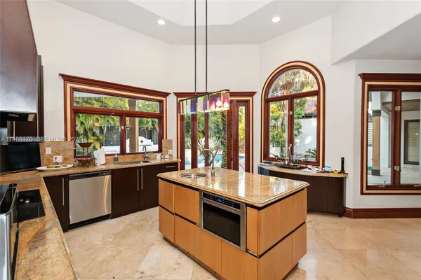 a kitchen with stainless steel appliances granite countertop a stove and a view of living room