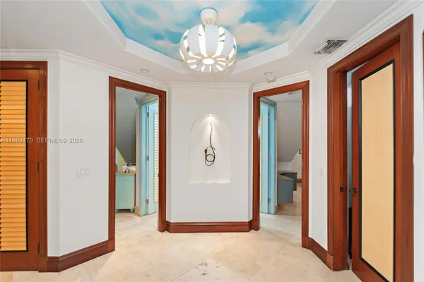 a view of a hallway with a dining table and chandelier