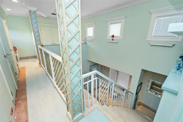 a view of staircase with lots of frames on wall and wooden floor