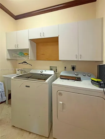 a bedroom with two beds and chandelier