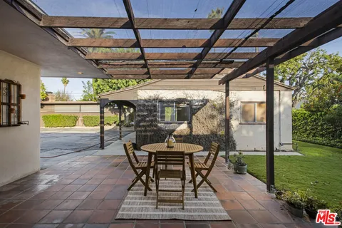 a dining room with furniture and a floor to ceiling window