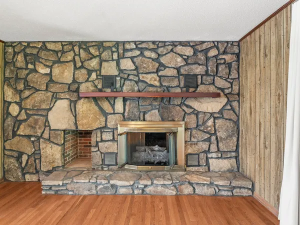 an empty room with wooden floor and a fireplace