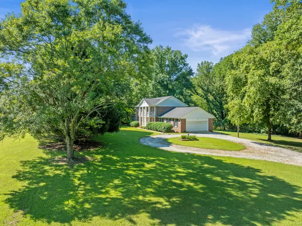 a view of a house with a yard and swimming pool