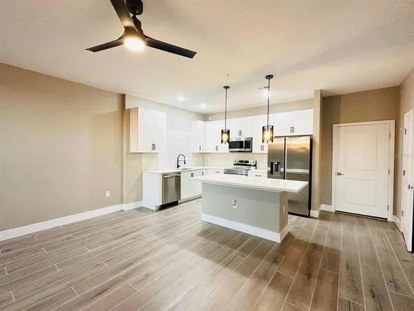 a kitchen with stainless steel appliances kitchen island a refrigerator and a sink