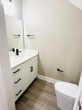 a bathroom with a toilet sink and mirror