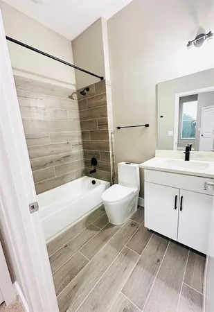 a bathroom with a white tub a toilet a sink and a mirror
