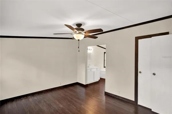 a view of a livingroom with wooden floor and a ceiling fan