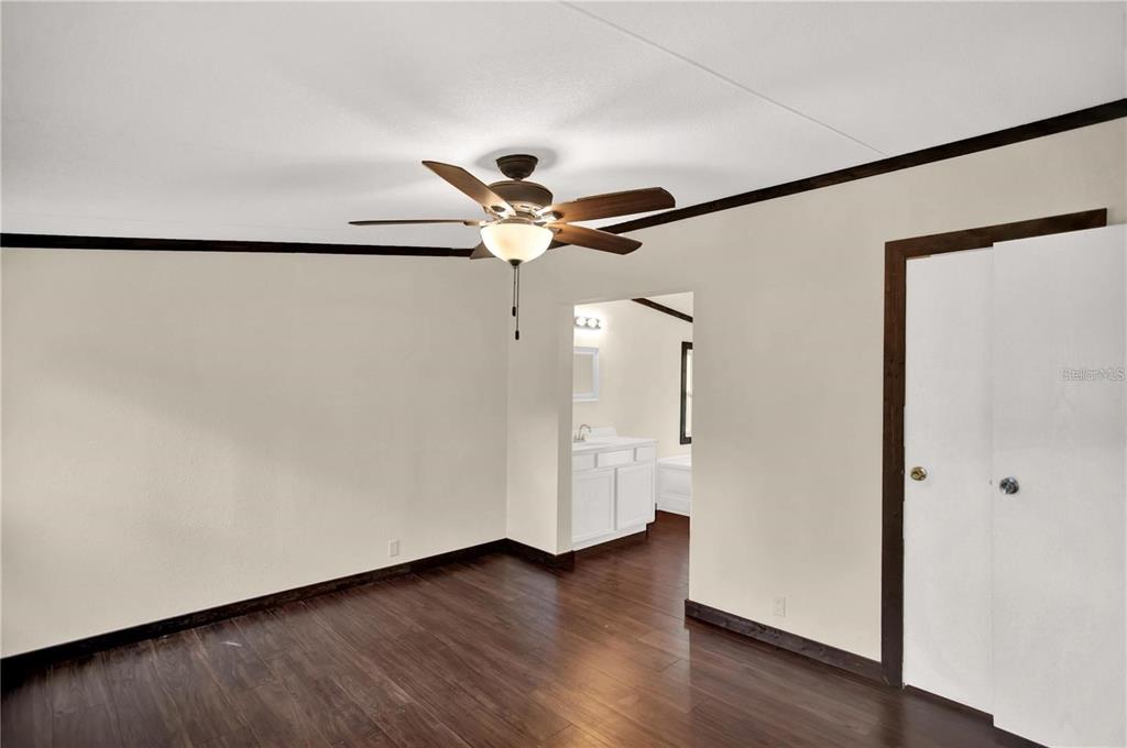 10650 Northwest 190th Street Micanopy, FL 32667 - Photo 17 of 31 a view of a livingroom with wooden floor and a ceiling fan
