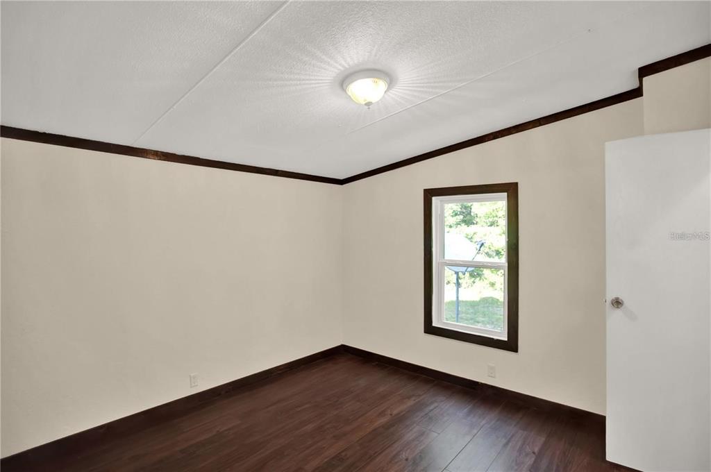 10650 Northwest 190th Street Micanopy, FL 32667 - Photo 26 of 31 a view of an empty room with wooden floor and a window
