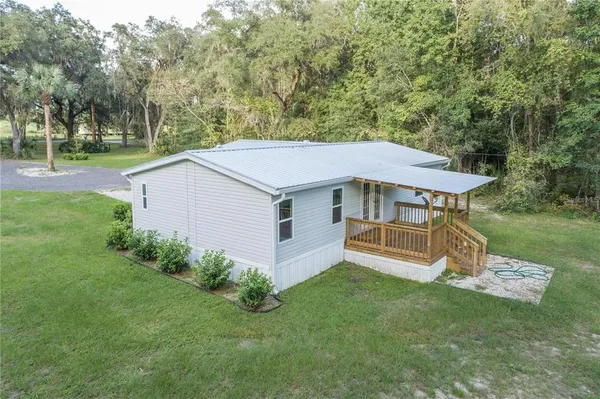 an aerial view of a house with a yard table and chairs