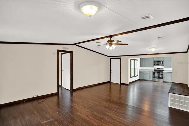 a view of an empty room with wooden floor