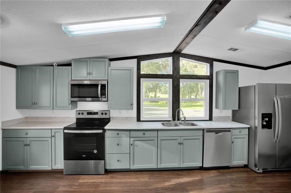 10650 Northwest 190th Street Micanopy, FL 32667 - Photo 6 of 31 a kitchen with stainless steel appliances granite countertop a stove a sink and a refrigerator