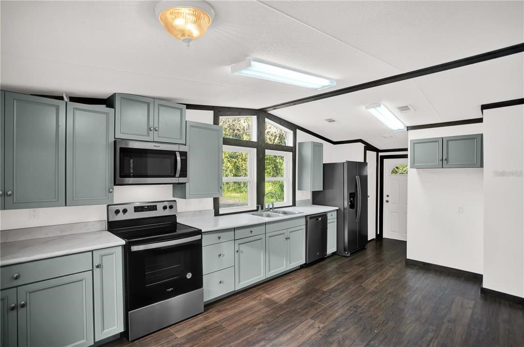 10650 Northwest 190th Street Micanopy, FL 32667 - Photo 7 of 31 a kitchen with a stove a sink and a refrigerator