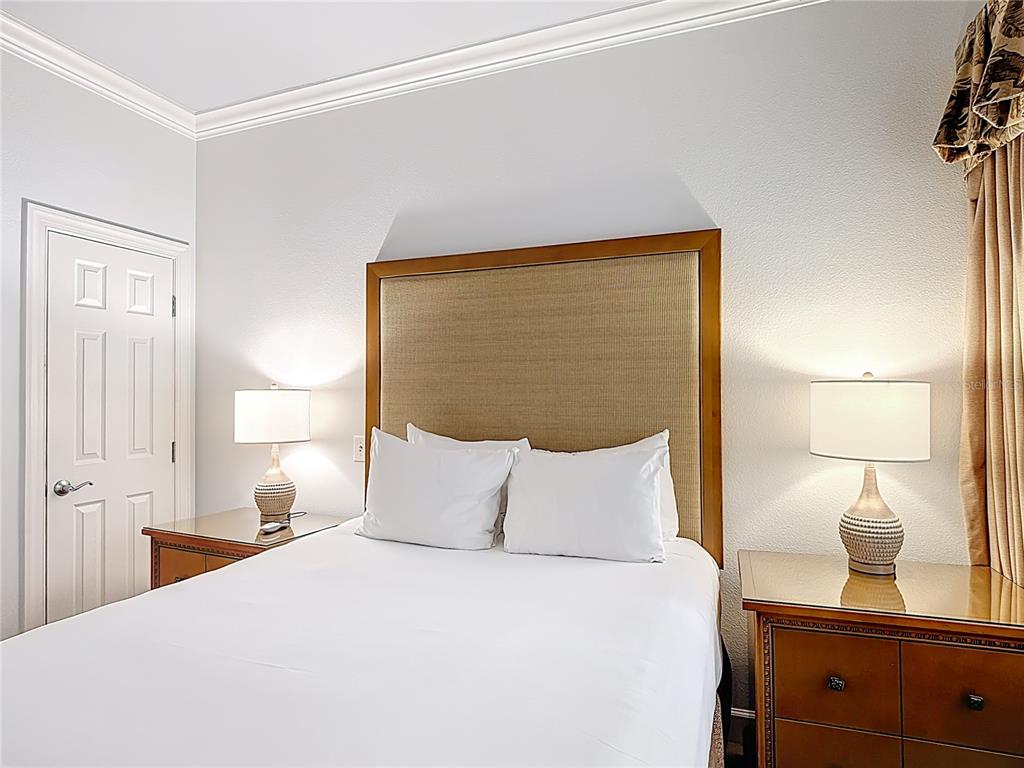 1356 Centre Ct Ridge Drive, Unit 103 Reunion, FL 34747 - Photo 22 of 53 a bedroom with a bed and a lamp on dresser