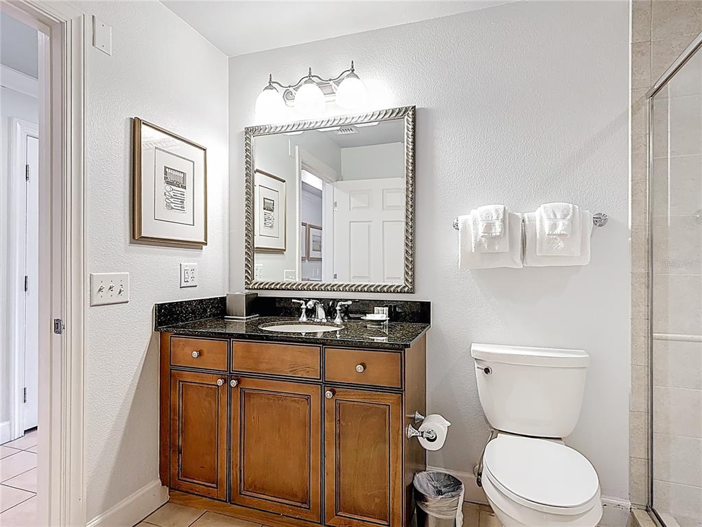 1356 Centre Ct Ridge Drive, Unit 103 Reunion, FL 34747 - Photo 24 of 53 a bathroom with a granite countertop toilet sink and mirror