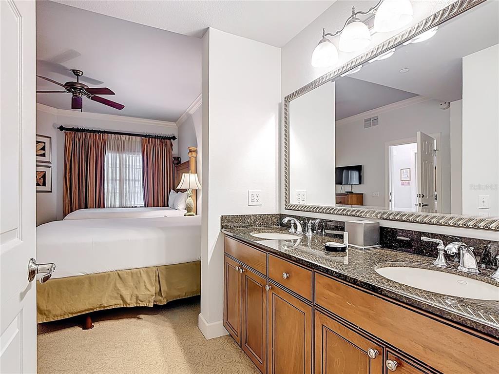 1356 Centre Ct Ridge Drive, Unit 103 Reunion, FL 34747 - Photo 31 of 53 a bedroom with a double vanity sink and a mirror