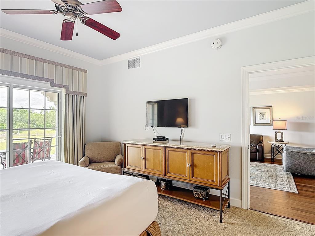 1356 Centre Ct Ridge Drive, Unit 103 Reunion, FL 34747 - Photo 32 of 53 a bedroom with a bed and a flat screen tv