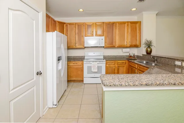 a kitchen with stainless steel appliances granite countertop a refrigerator a sink and a stove