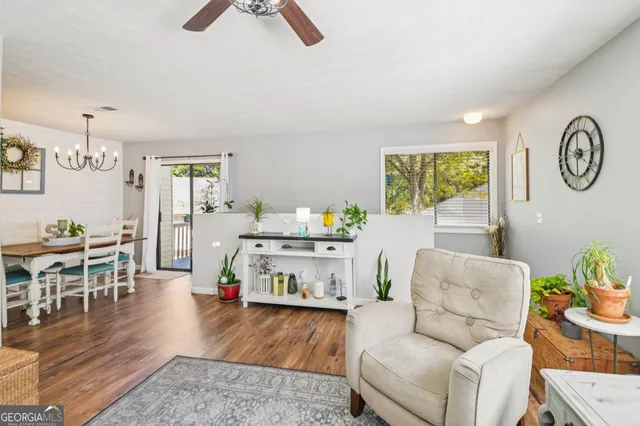 a living room with furniture a chandelier and a floor to ceiling window