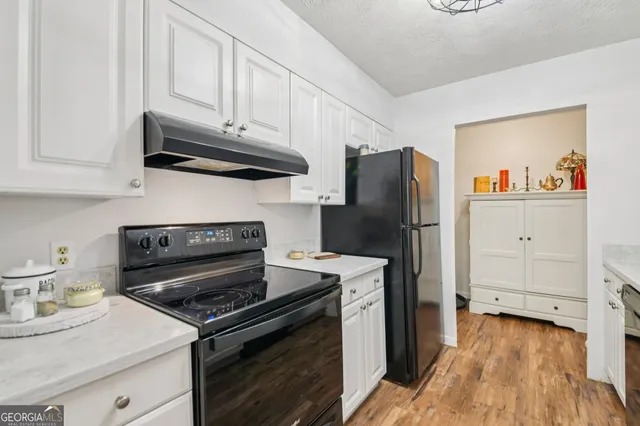 a kitchen with granite countertop a sink a stove and cabinets