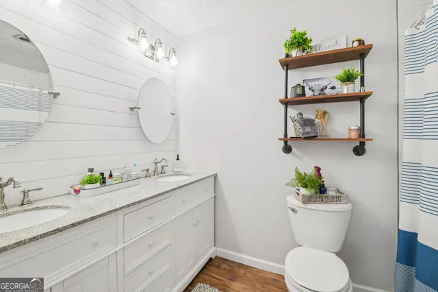 a bedroom with a bed and a flat tv screen on dresser