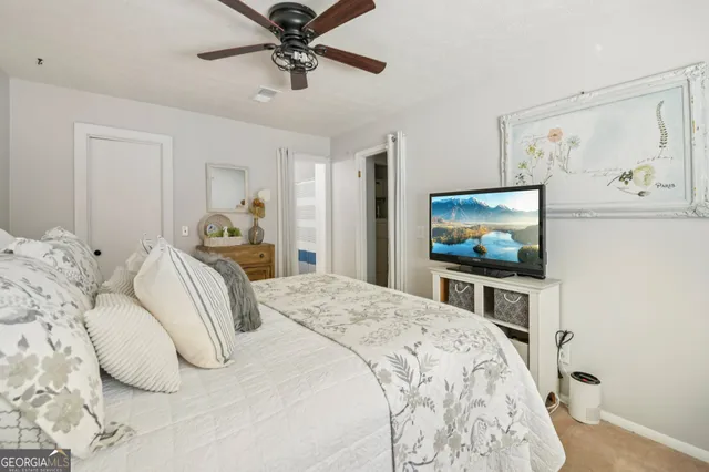 a bedroom with a bed and a mirror on the dresser